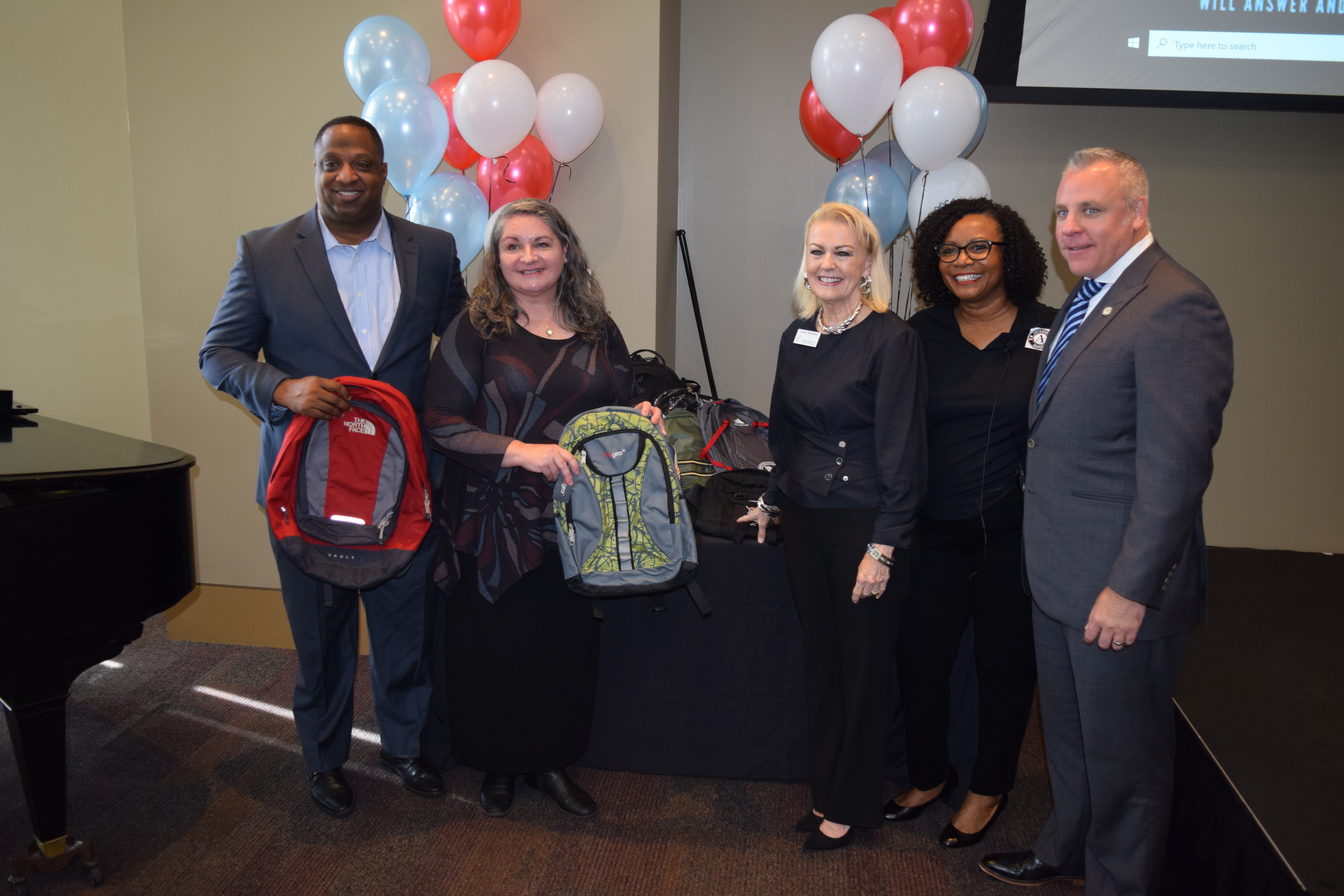 Members of the Georgia Commission for Service and Volunteerism and Veterans Empowerment Organization pose with backpacks from a service project. 